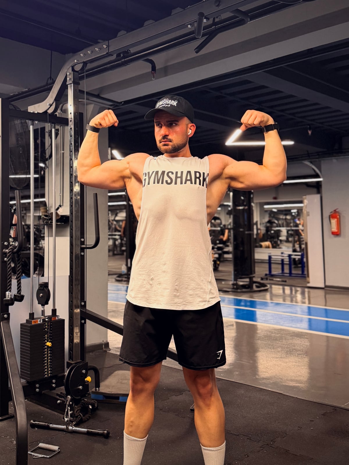 Omid Mirzaei (Omid Hybrid) posing a double-bicep flex in the gym