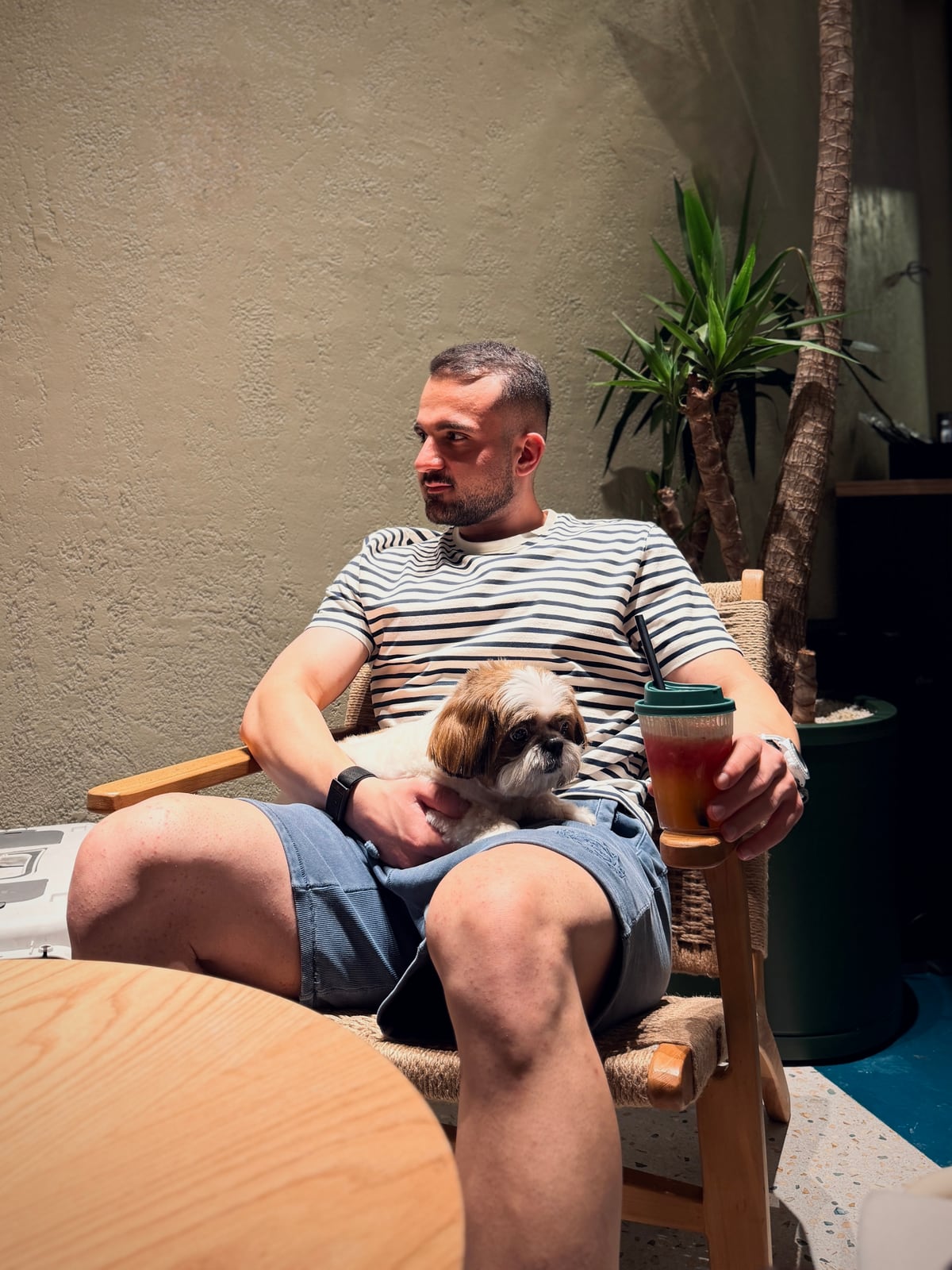 Omid Mirzaei sitting with a small dog on his lap